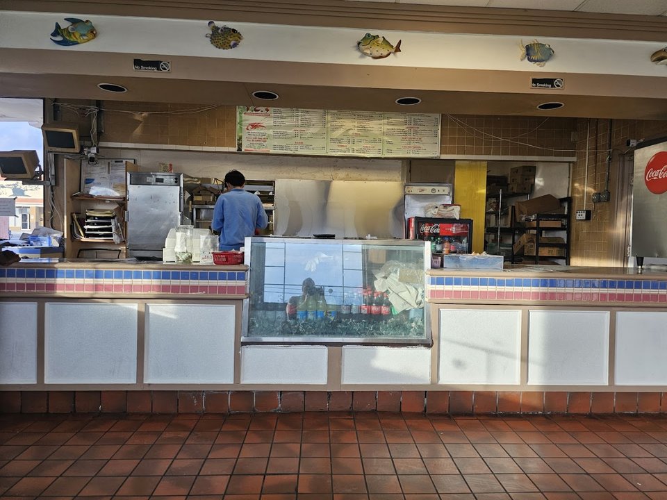 Seafood restaurant interior with simple seating and counter service.